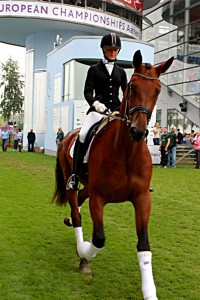 Das Foto zeigt eine Reiterin auf einem Pferd