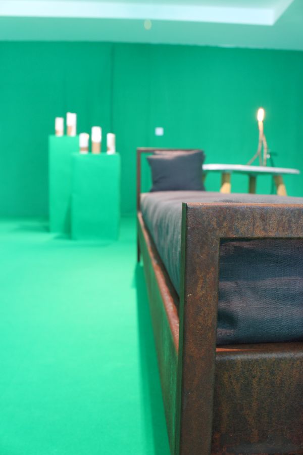 Das Foto zeigt einen grünlich beleuchteten Raum mit einem Bett