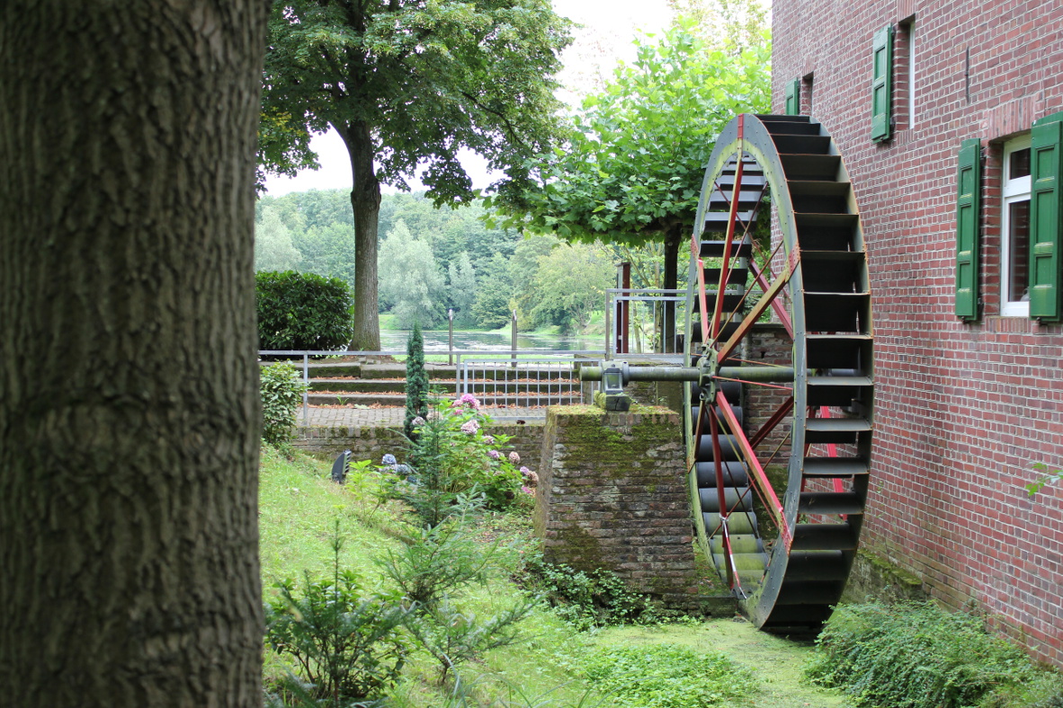 Das Foto zeigt ein Haus mit einem Wasserrad